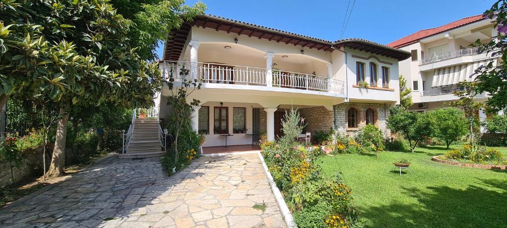 a large white house with a garden in front of it at Veranda B&B in Berat