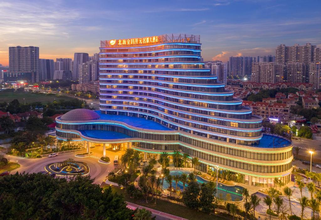 a large building with a pool in front of a city at Golden Shining New Century Grand Hotel Beihai in Beihai