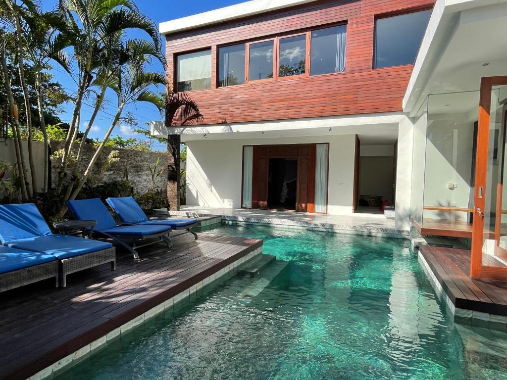 a villa with a swimming pool and a house at Villa Sassy in Seminyak