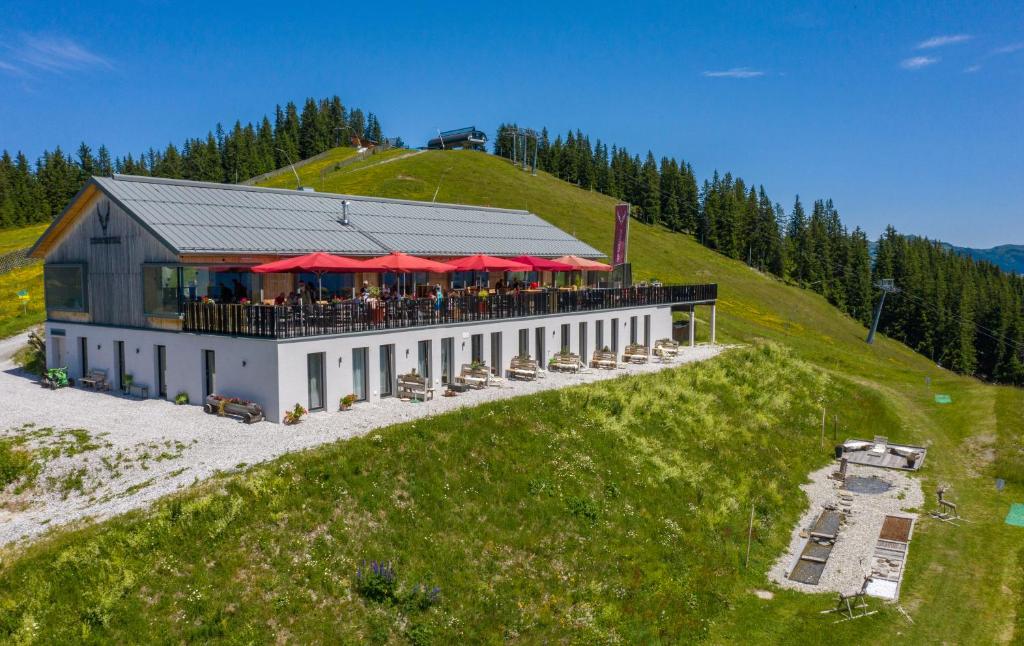 ein Gebäude mit einem Restaurant auf einem Hügel in der Unterkunft Schmiedhof Alm in Zell am See