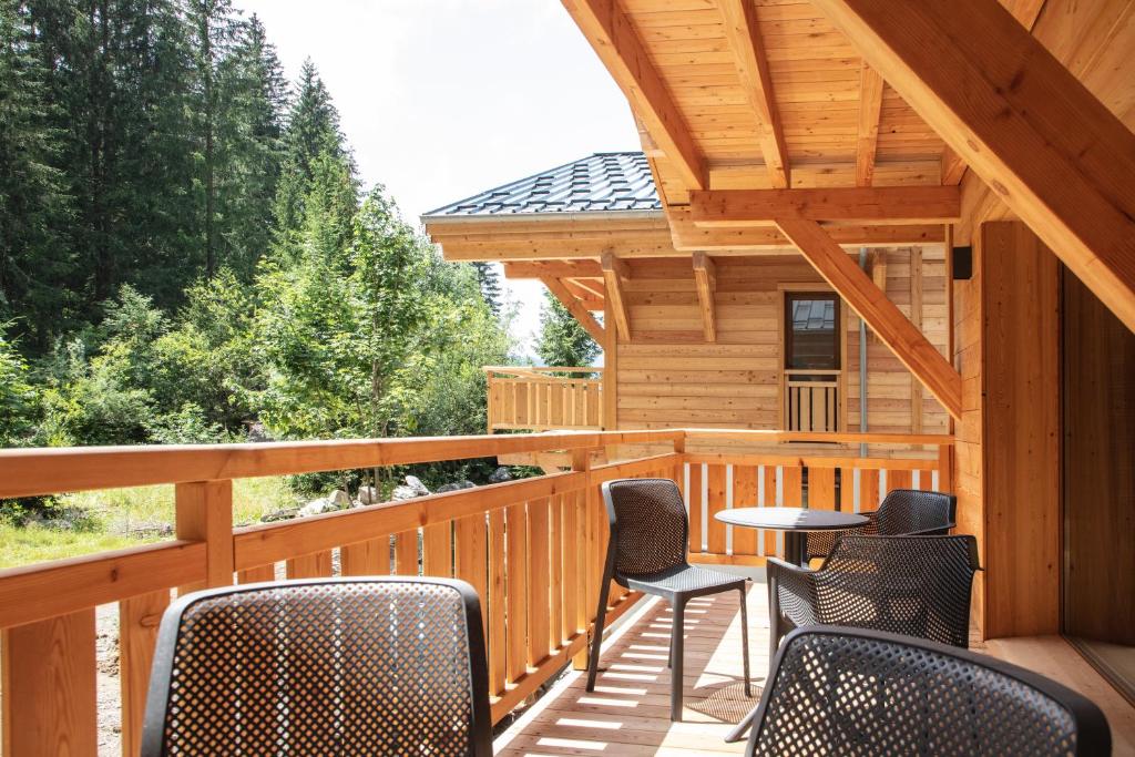 eine Terrasse mit Stühlen und Tischen in einer Hütte in der Unterkunft TERRESENS - Les 3 Sophie in Morzine