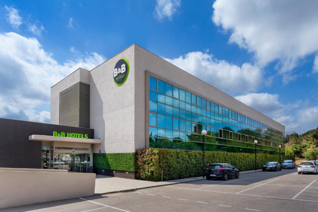 un parcheggio di fronte a un edificio di B&B HOTEL Barcelona Sant Cugat a Sant Cugat del Vallès