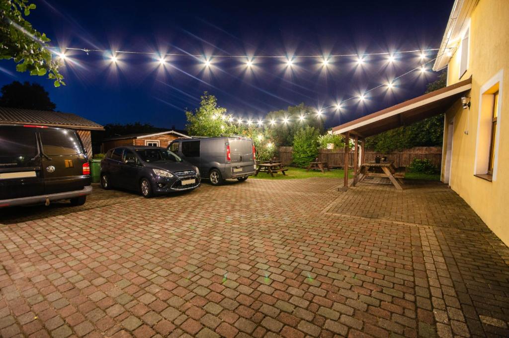 a parking lot with two vehicles parked under lights at Olle Holiday house in Ventspils