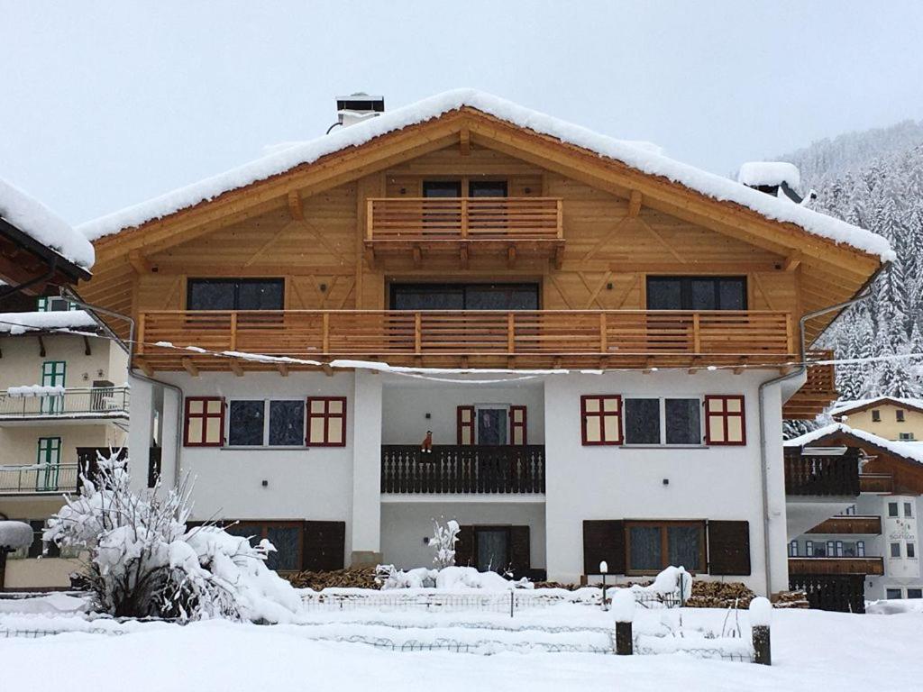 a house with snow on the roof at Appartamenti Cèsa Sorèie Dolomiti in Canazei