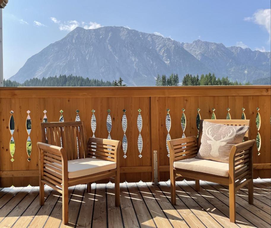 two chairs on a deck with a view of a mountain at Panorama Lodge Mountainview 208 in Tauplitz