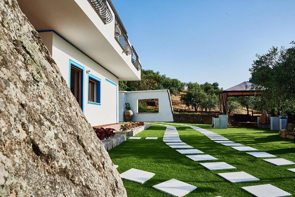un giardino con passerella in pietra accanto a una casa di B&B Tiscali a Dorgali
