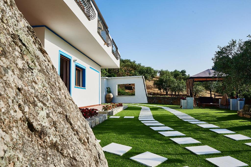 un jardín con una pasarela de piedra junto a una casa en B&B Tiscali, en Dorgali