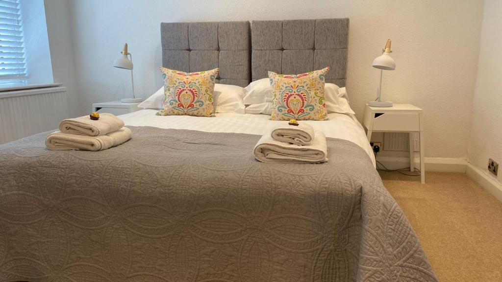 um quarto com uma cama grande e toalhas em Tyan, Ambleside em Ambleside
