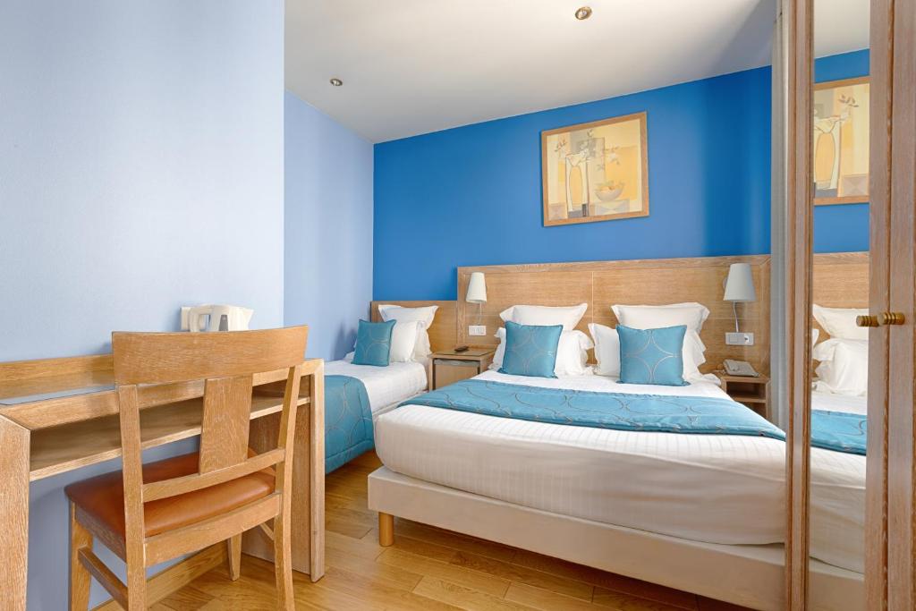 - une chambre avec 2 lits aux murs bleus dans l'établissement Grand Hotel Dore, à Paris