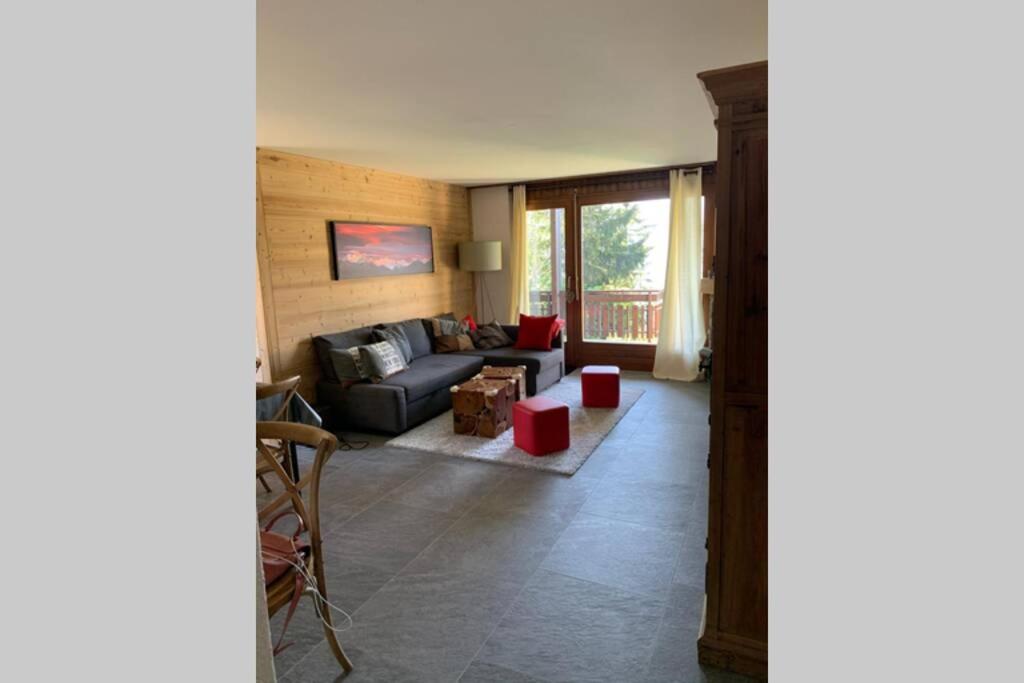 ein Wohnzimmer mit einem Sofa und einem Tisch in der Unterkunft Appartement familial cosy - 2 à 6 personnes in Crans-Montana