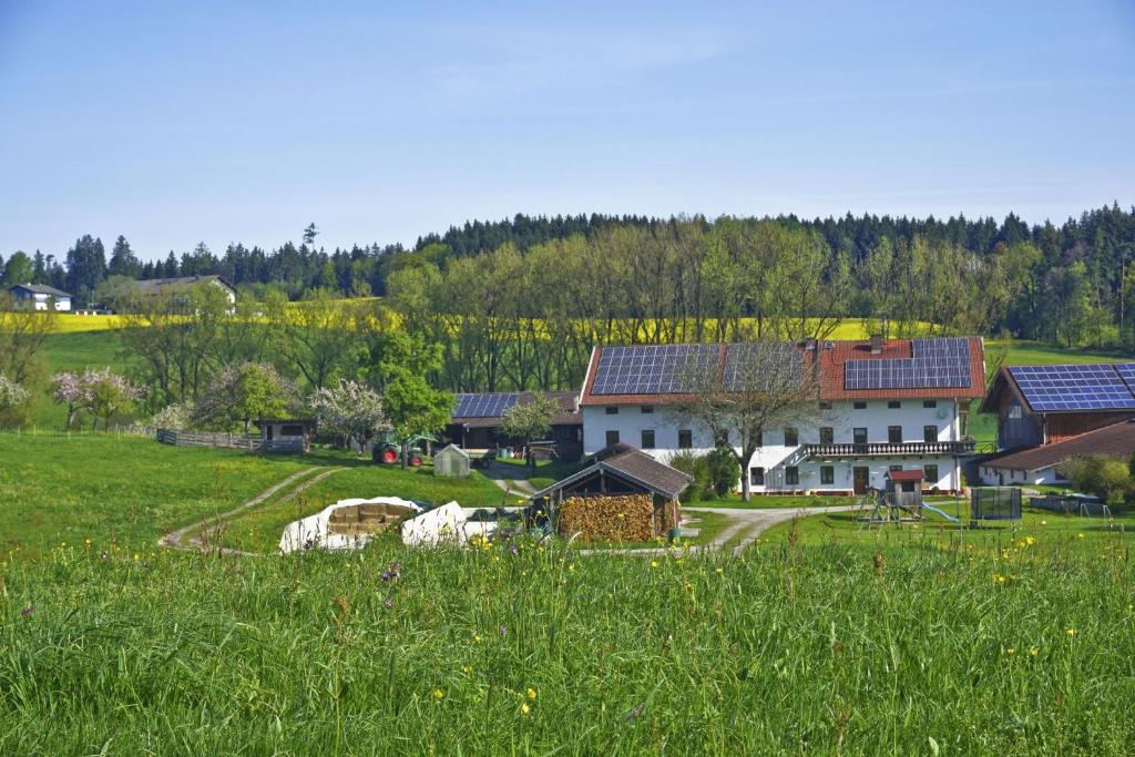 a large field of grass with a house in the background at Paulhof am Chiemsee in Seeon-Seebruck