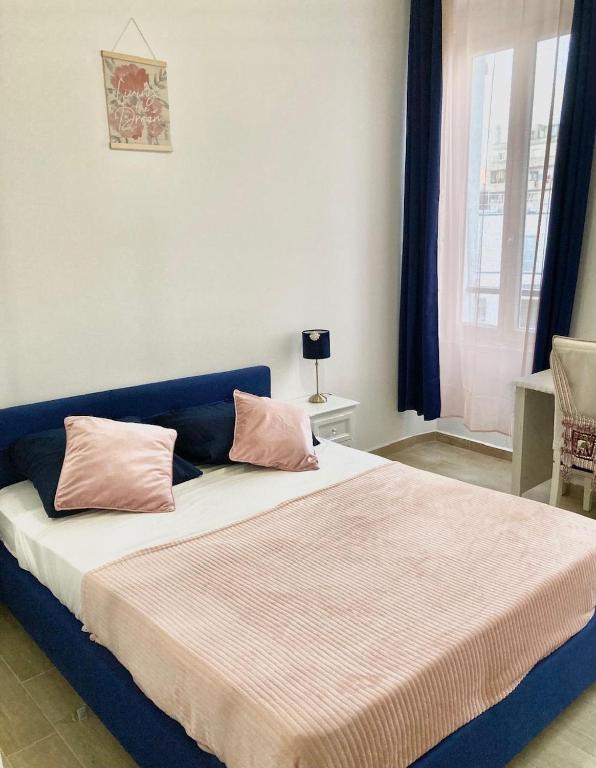 a bedroom with a bed with pink pillows on it at Charmant F4 proche de la gare Saint Charles in Marseille