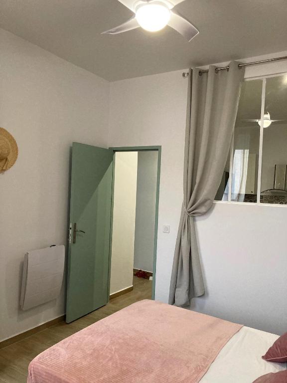 a bedroom with a green door and a window at Charmant F4 proche de la gare Saint Charles in Marseille