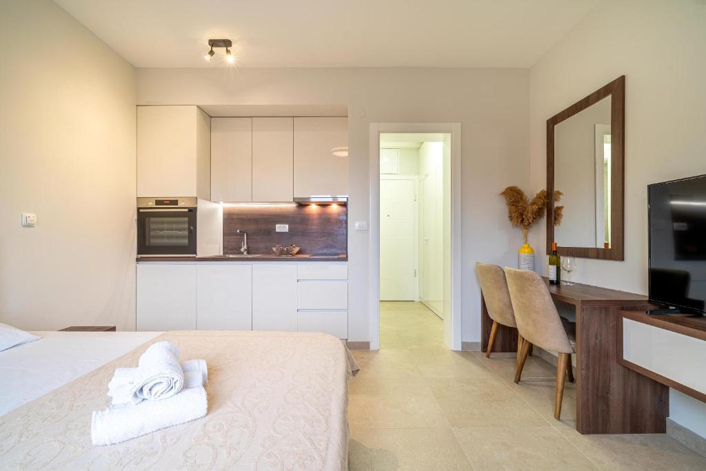 une chambre avec un lit et une cuisine avec une table dans l'établissement Studio apartment N2, à Tivat