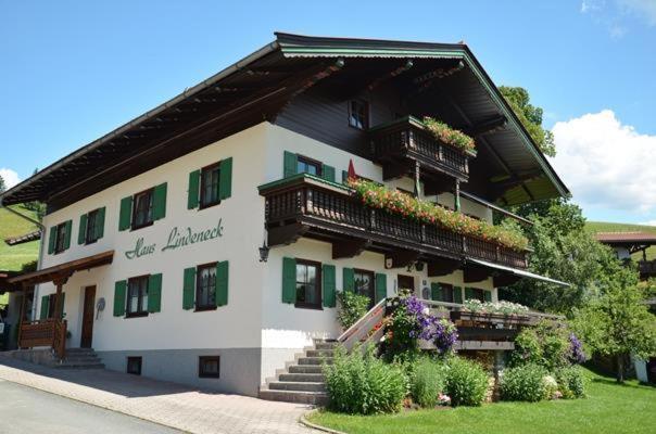 duży budynek z balkonami i kwiatami na nim w obiekcie Haus Lindeneck - Erika Schwentner w mieście Kössen