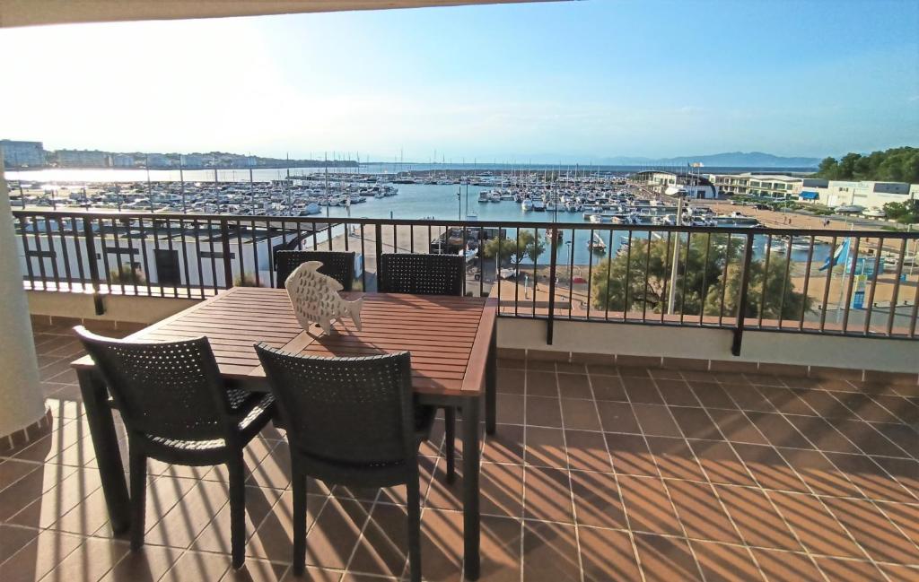 a table and chairs on a balcony with a view of a harbor at Apartaments Club Nautic L'Escala in L'Escala