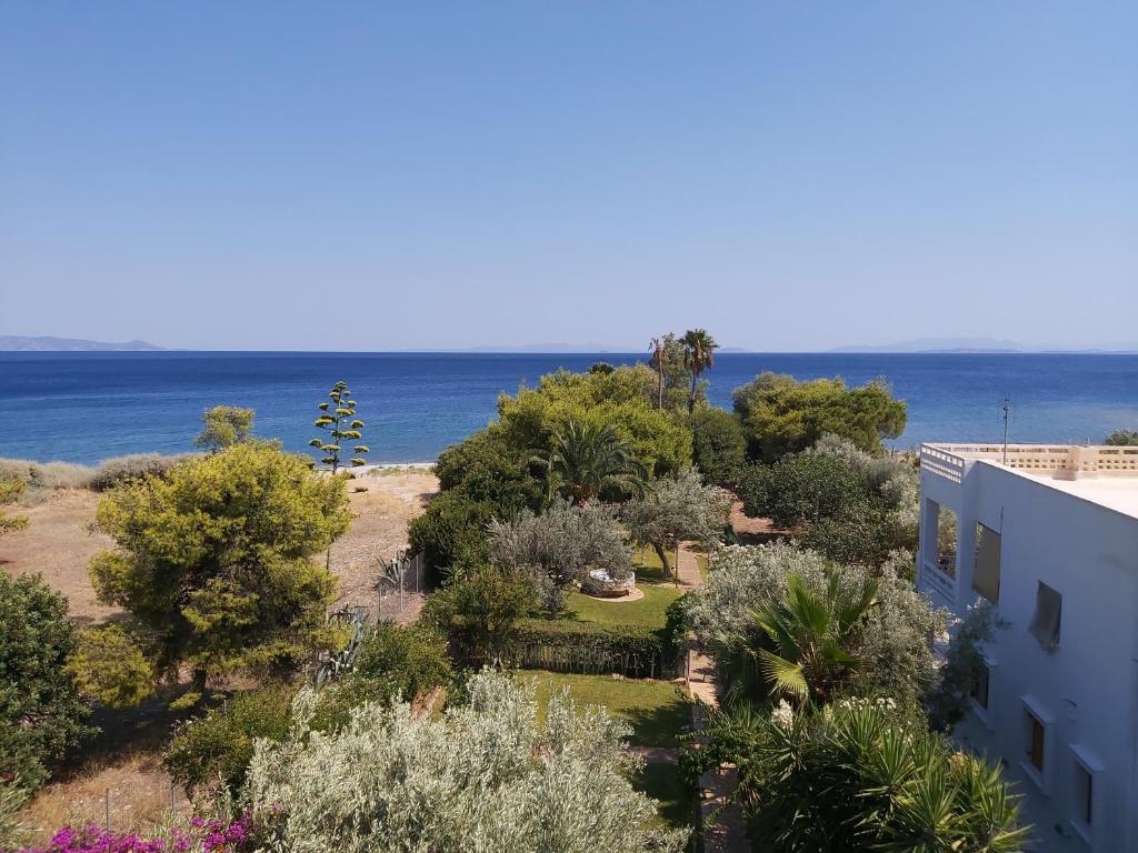 a view of a garden with the ocean in the background at Geranium Villa by the sea in Kineta