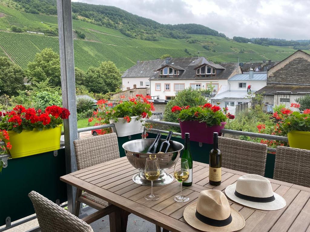 einen Tisch mit Hüten und Weingläsern auf dem Balkon in der Unterkunft Katrin-Cara Mia Ferienwohnung in Trittenheim