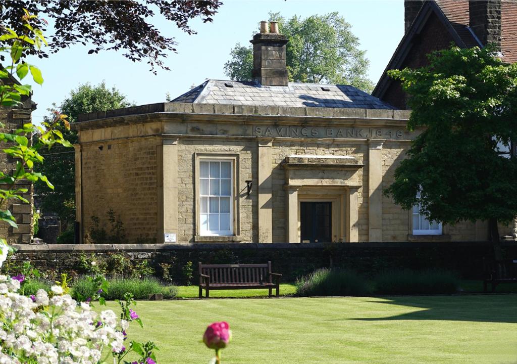 an old brick building with a bench in the yard at Beautiful old bank in Bakewell in Bakewell