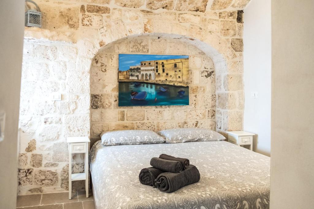 a bedroom with a bed in a stone wall at Dimore del Borgo Antico - Il Nido al mare in Monopoli