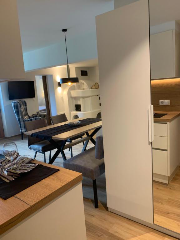 eine Küche und ein Wohnzimmer mit einem Tisch und Stühlen in der Unterkunft BUSSLEHNER Apartments in Achenkirch