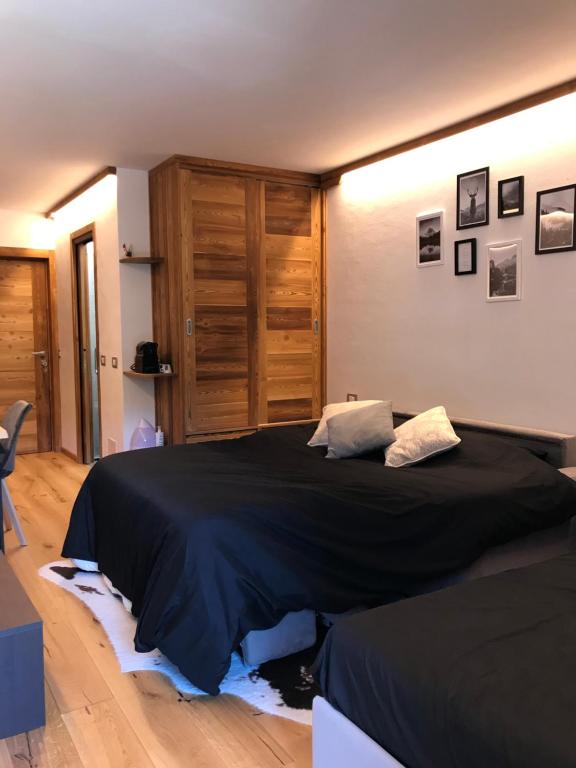 een slaapkamer met een groot bed en een zwarte deken bij Cozy studio apartment (110) in Breuil-Cervinia