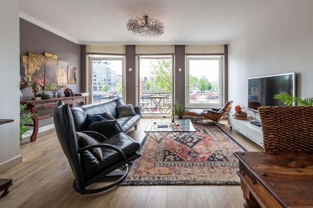 a living room with a leather couch and a tv at Amstel Riverside Apartment in Amsterdam