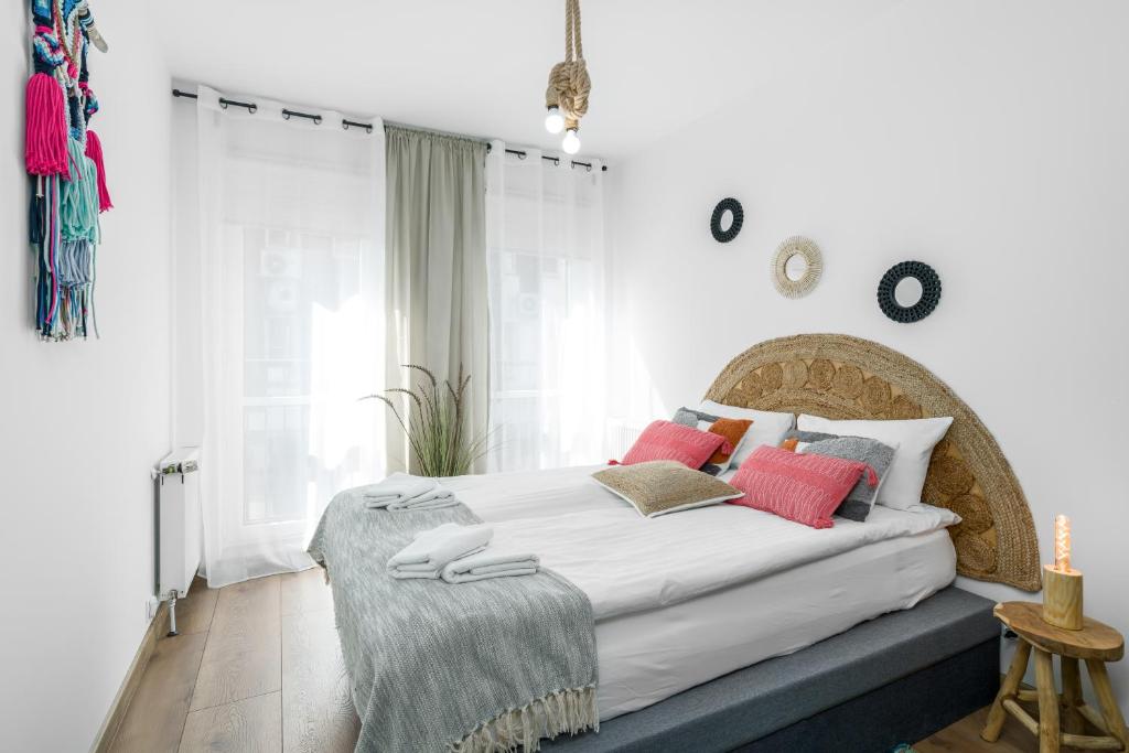 a bedroom with a large bed with red pillows at Sleepway Apartments - Boho Dream in Poznań