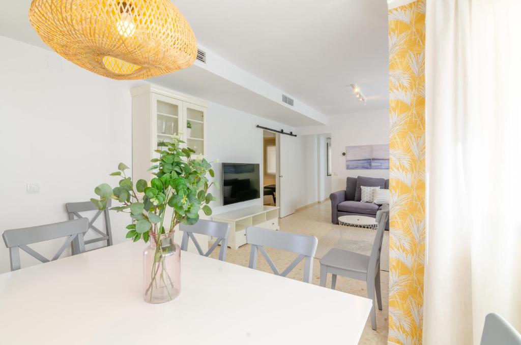 comedor y sala de estar con mesa blanca y sillas en Del Parque Flats Candelaria Rincon, en Rincón de la Victoria