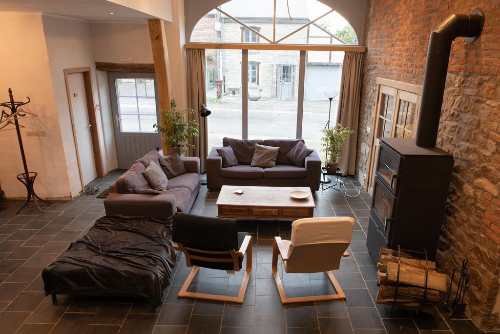 a living room with couches and a brick wall at Maison Druyard huis met 5 slaapkamers in Durbuy