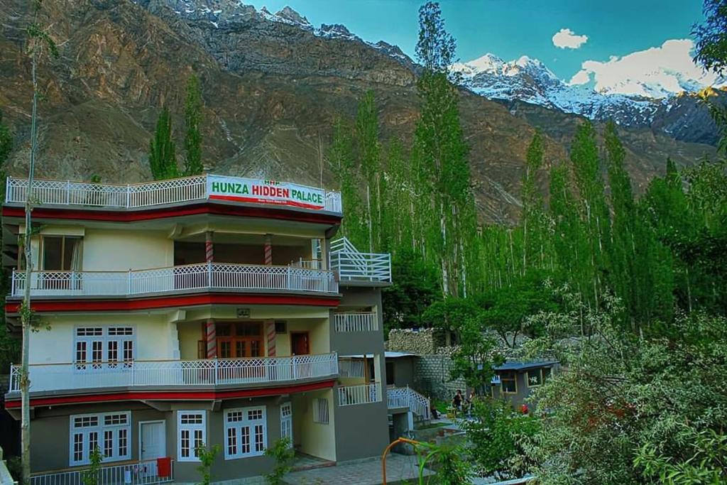a hotel building with a mountain in the background at Hunza Hidden Palace in Alīābād