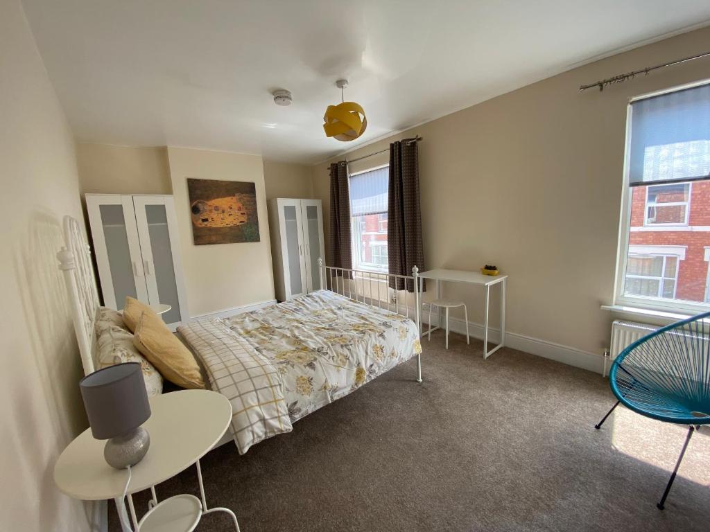 a bedroom with a bed and a table and a window at Edinburgh Place in Kettering