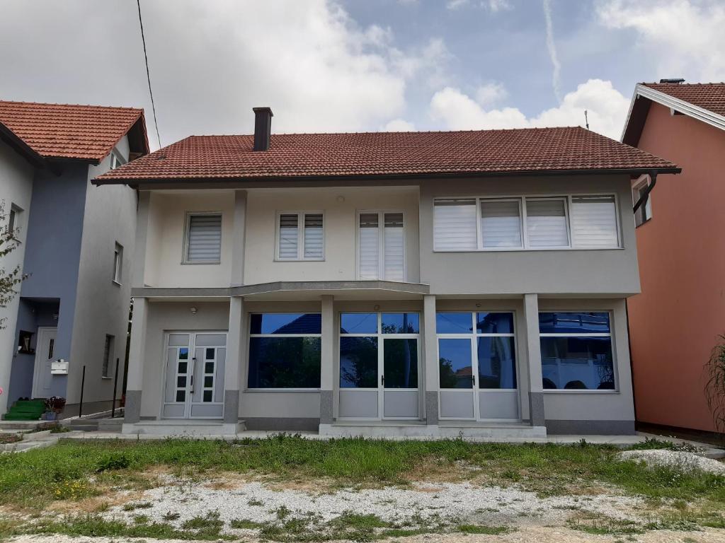 AS guesthouse في Krževići: منزل بأبواب بيضاء ونوافذ