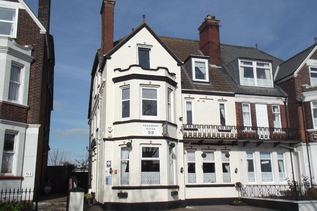 an old white house with a balcony on a street at Beaumont House in Great Yarmouth