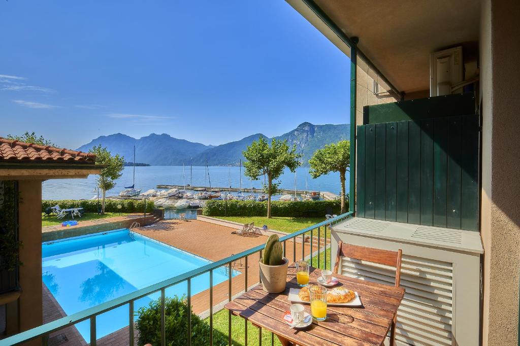 a balcony with a table and a swimming pool at Aria di Breva in Lierna