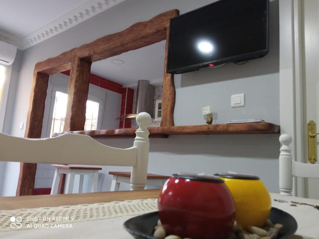 a plate of fruit on a table with a television at Casa La Maravilla in Jerez de la Frontera