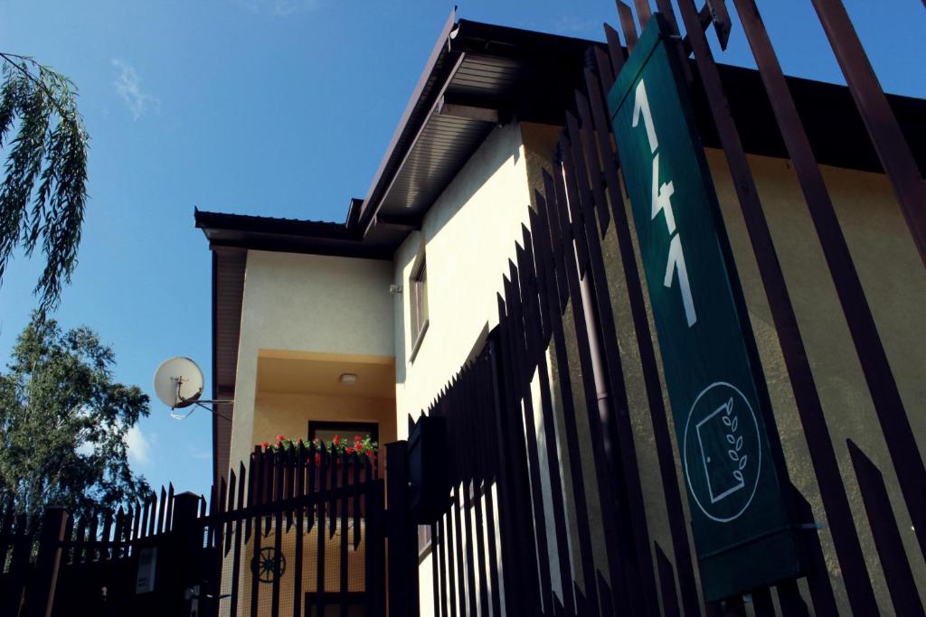 a fence in front of a house with a street sign at Zielone Drzwi in Starachowice