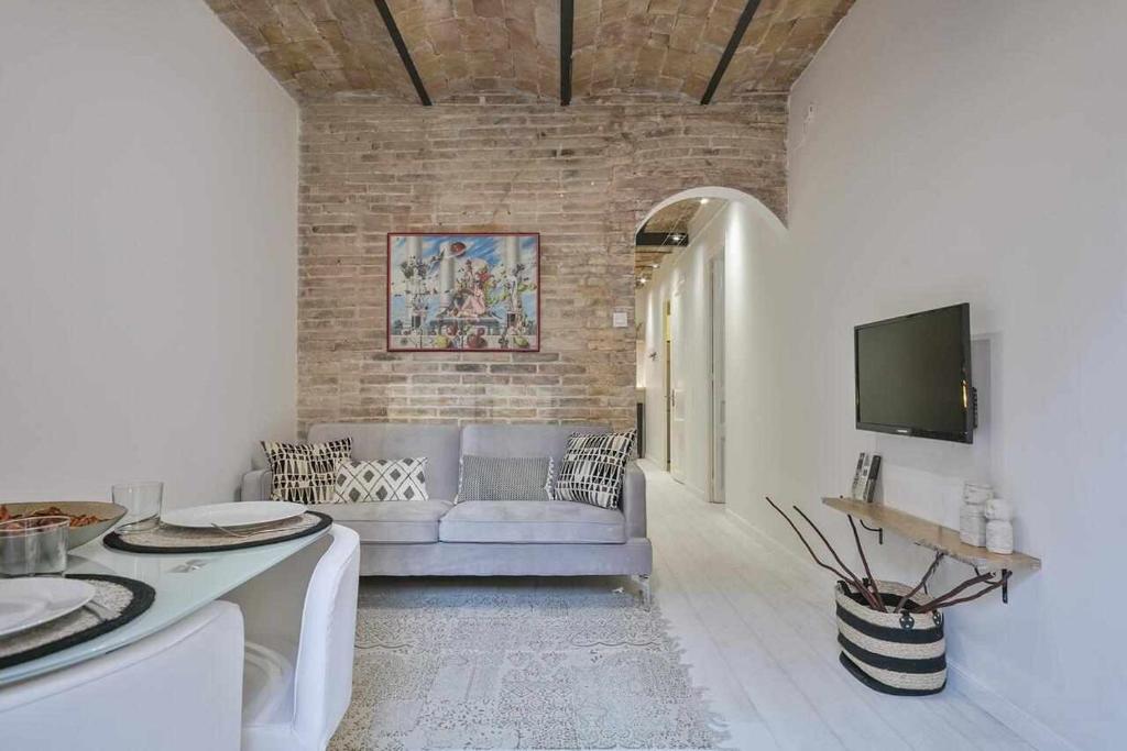 een woonkamer met een bank en een tv bij Apartamento Alejandro en BCN in Barcelona