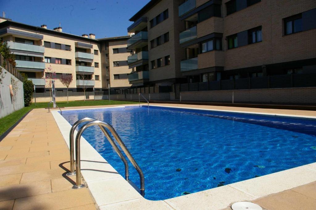 a swimming pool in front of a building at Apartamento PR 39 terraza y piscina Tossa de Mar in Tossa de Mar