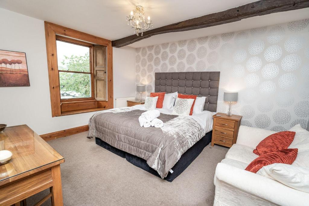 um quarto com uma cama, um sofá e uma janela em Bridge House Apartment 2 em Keswick