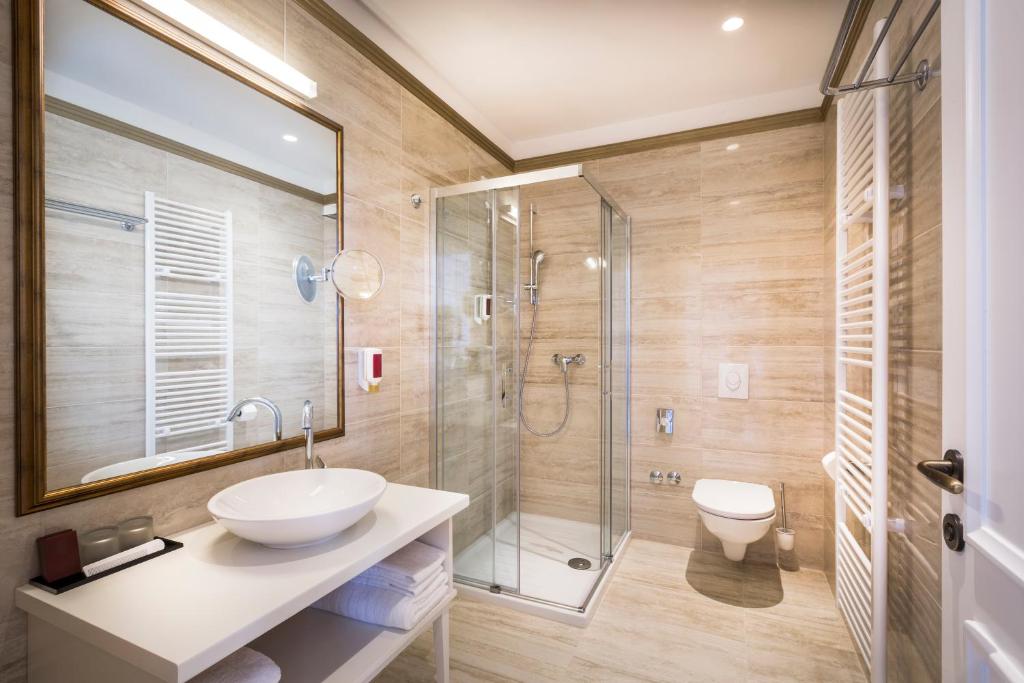 a bathroom with a sink and a glass shower at Hotel Bellevue - Liburnia in Opatija