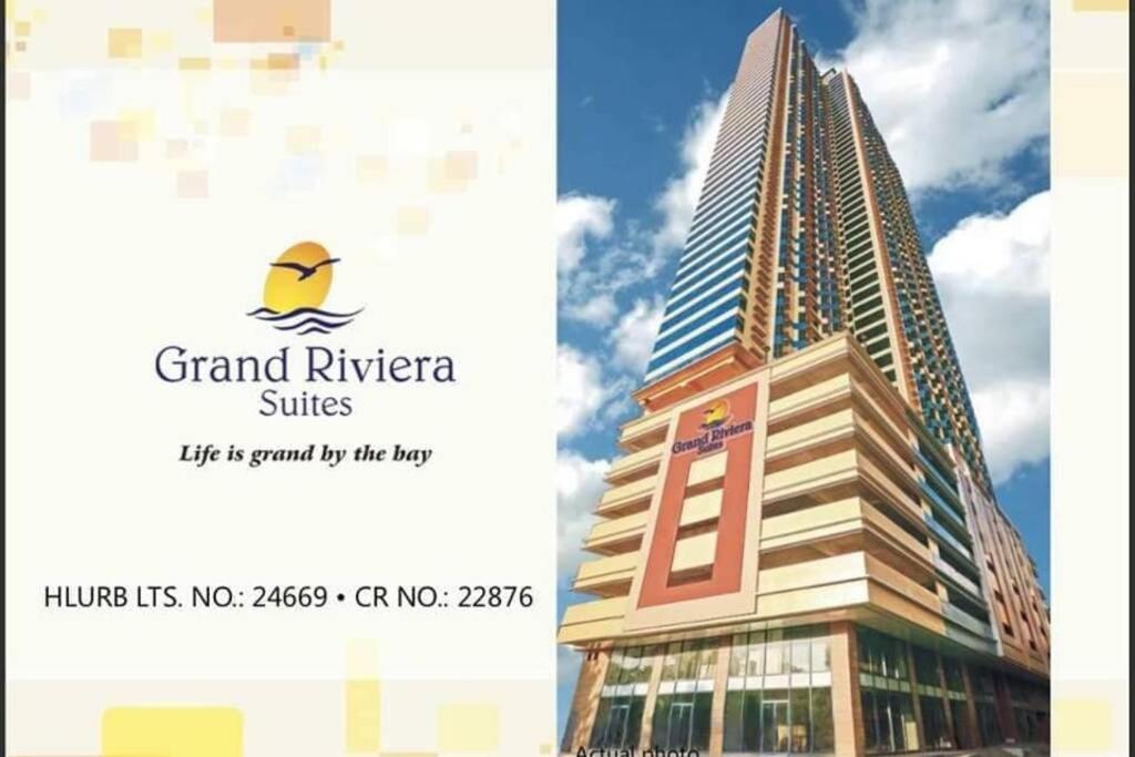 a picture of a tall building with the words grand riviera suites at Magnificent View of Manila Bay, Roxas Blvd, US Embassy in Manila