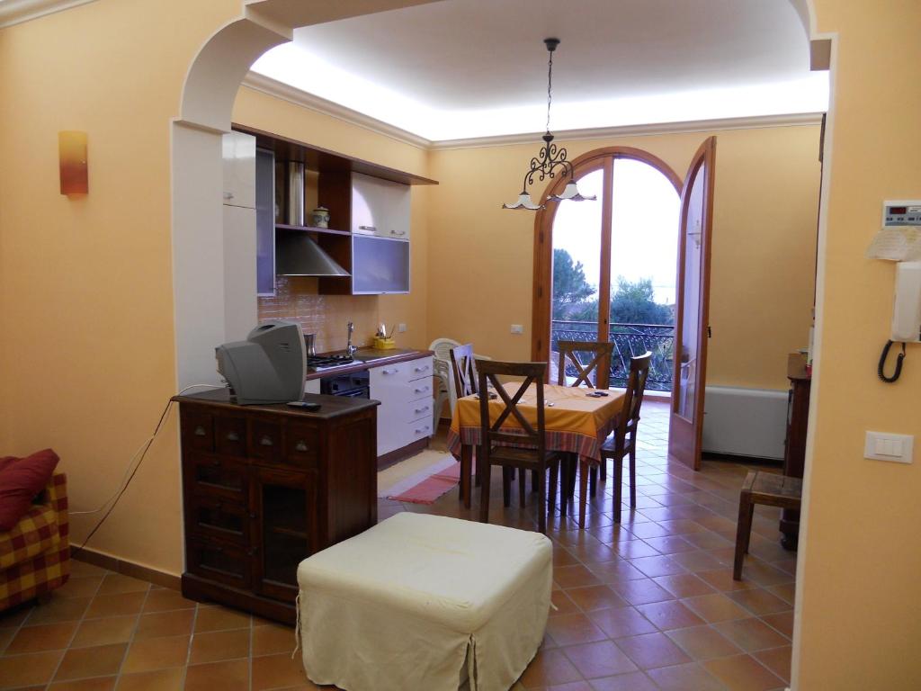 cocina y comedor con mesa y sillas en MARSALA - Appartamento per vacanze di fronte Isola di Mothya, en Marsala