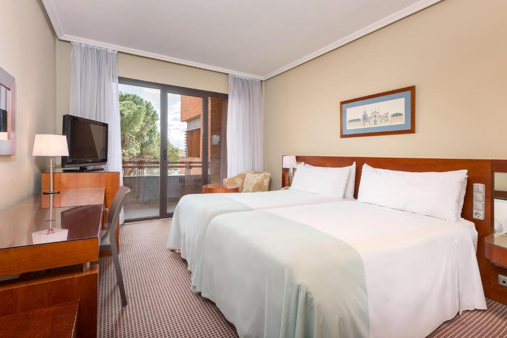 a hotel room with a large bed and a television at Hotel Madrid Alameda Aeropuerto, Affiliated by Meliá in Madrid