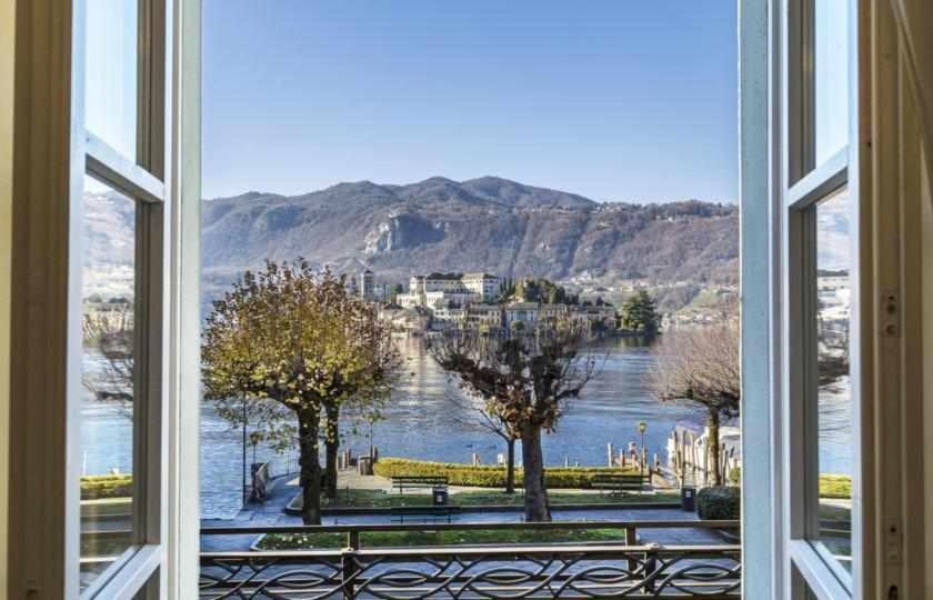 een open raam met uitzicht op een waterlichaam bij LISOLA Appartamento con vista lago in Orta San Giulio