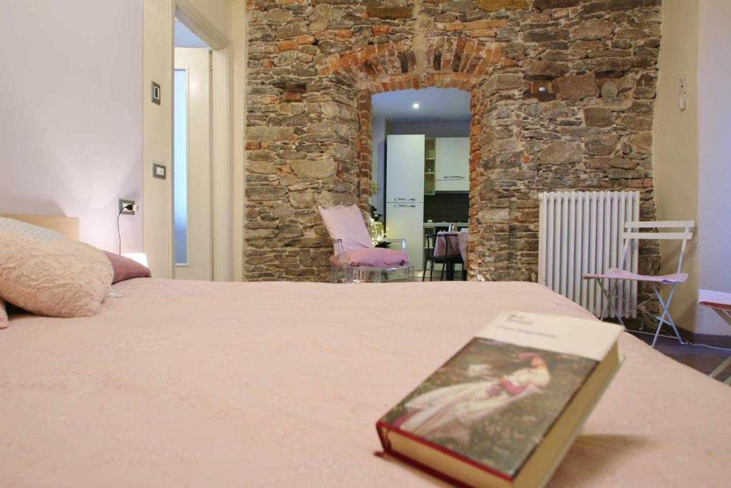 - un livre assis au-dessus d'un lit dans une chambre dans l'établissement LA PERLA piccolo appartamento in piazza, à Orta San Giulio