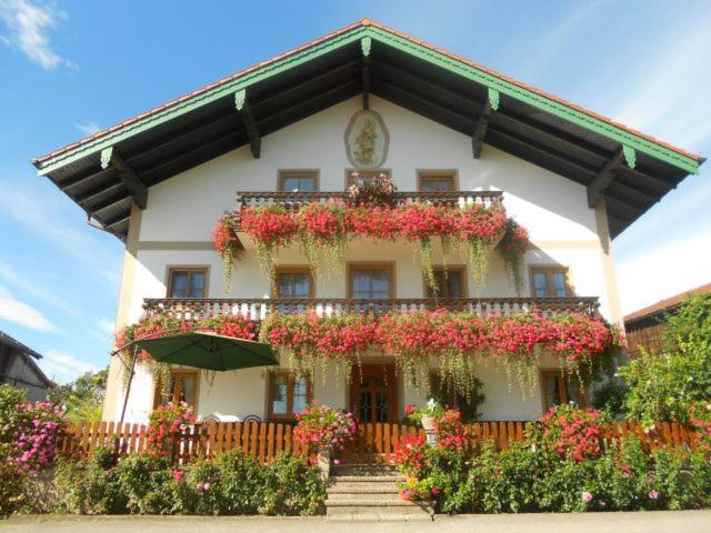 a building with flowers on the front of it at Lenzenhof, Familie Christian und Stefanie Spitzl in Frasdorf