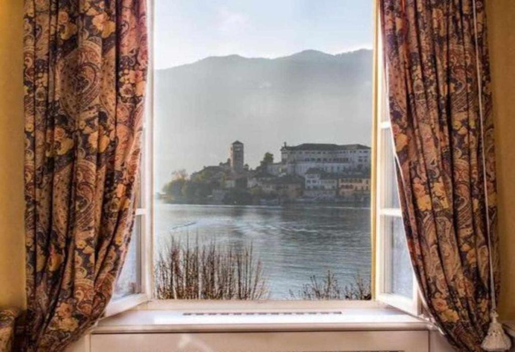 a window with a view of a body of water at Casa Orta appartamento con vista lago in Orta San Giulio