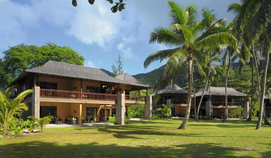 a resort with palm trees in front of it at Constance Ephelia in Port Glaud