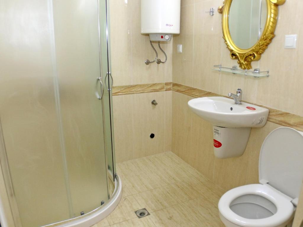a bathroom with a shower and a toilet and a sink at Sweet Homes Apartments in Sunny Beach
